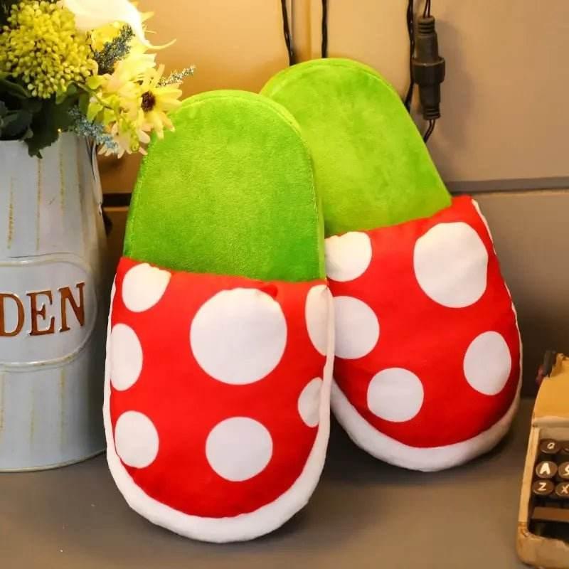 Plush green and red polka dot slippers on a desk beside a flower vase and phone