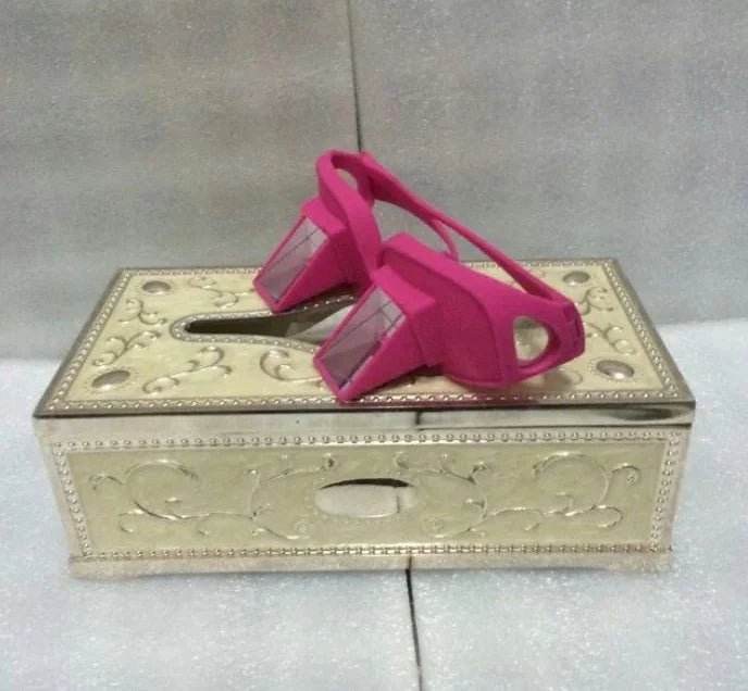 Pink prism glasses on ornate metallic tissue box, decorative home accessory display